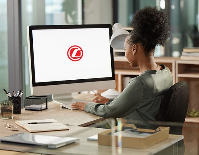 Femme travaillant à son bureau derrière un ordinateur où on voit le logo de Capital Bank
