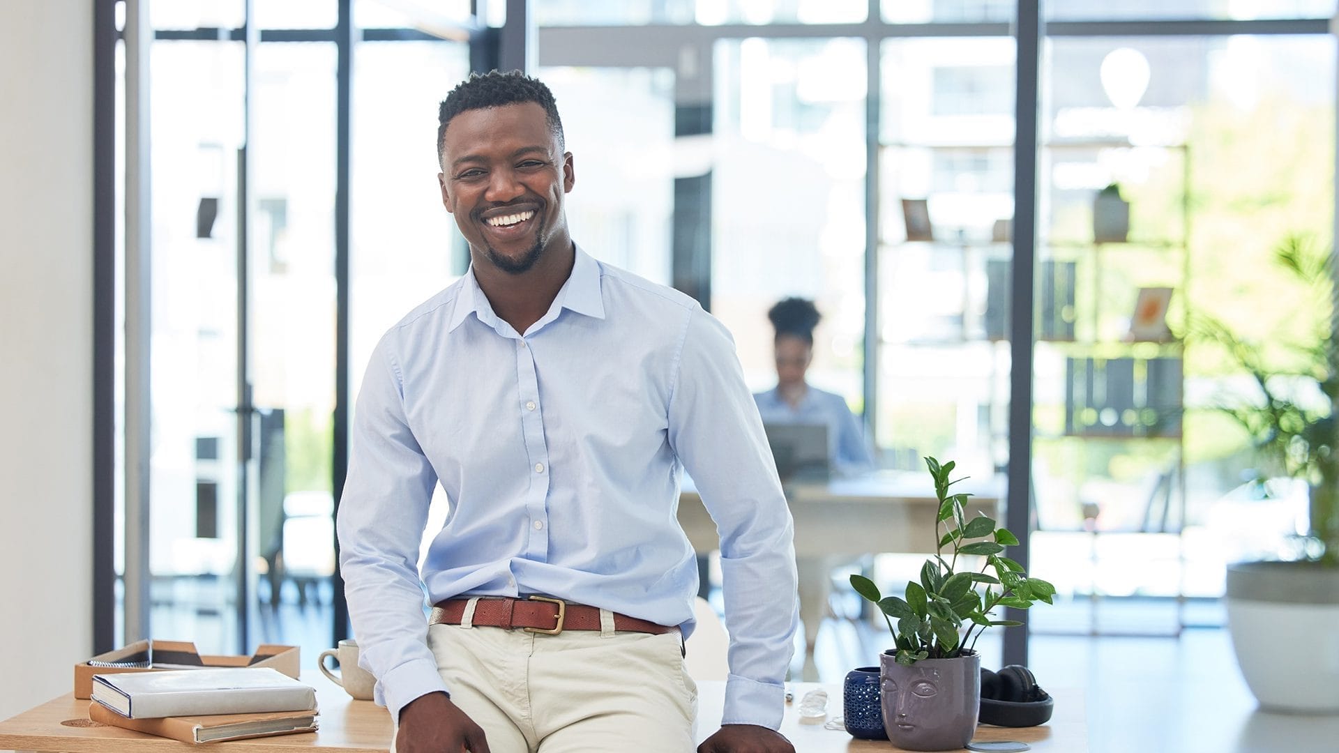 Homme, au bureau, heureux et souriant, assis sur son bureau