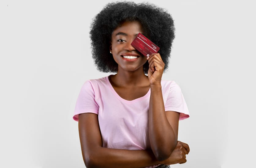 Femme souriant et tenant sa carte de débit Capital Pam dans une main