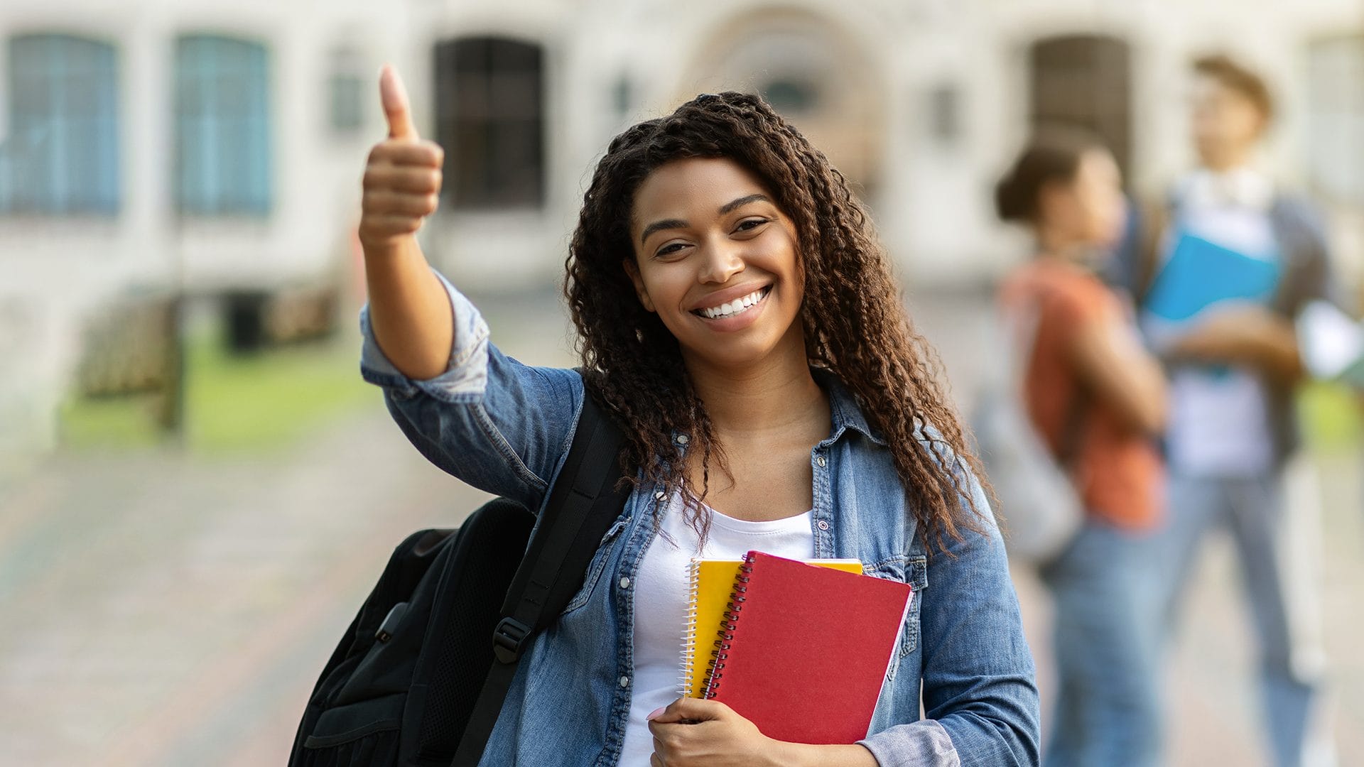 Jeune étudiante, souriant, portant son sac à dos et des cahiers