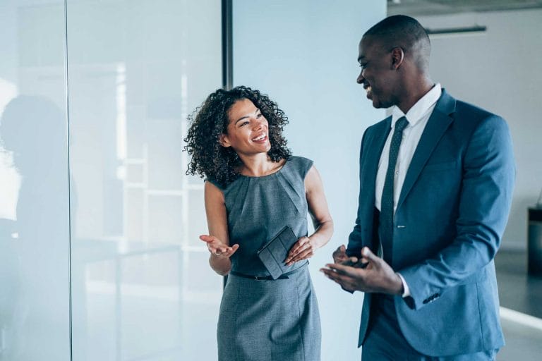 Homme et femme conversant professionnellement dans un bureau avec un sentiment de satisfaction